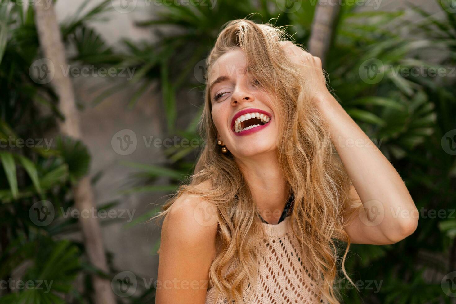 contento ridendo biondo donna in posa nel elegante tropicale villa. vacanza umore. rosso labbra, Perfetto Sorridi. foto