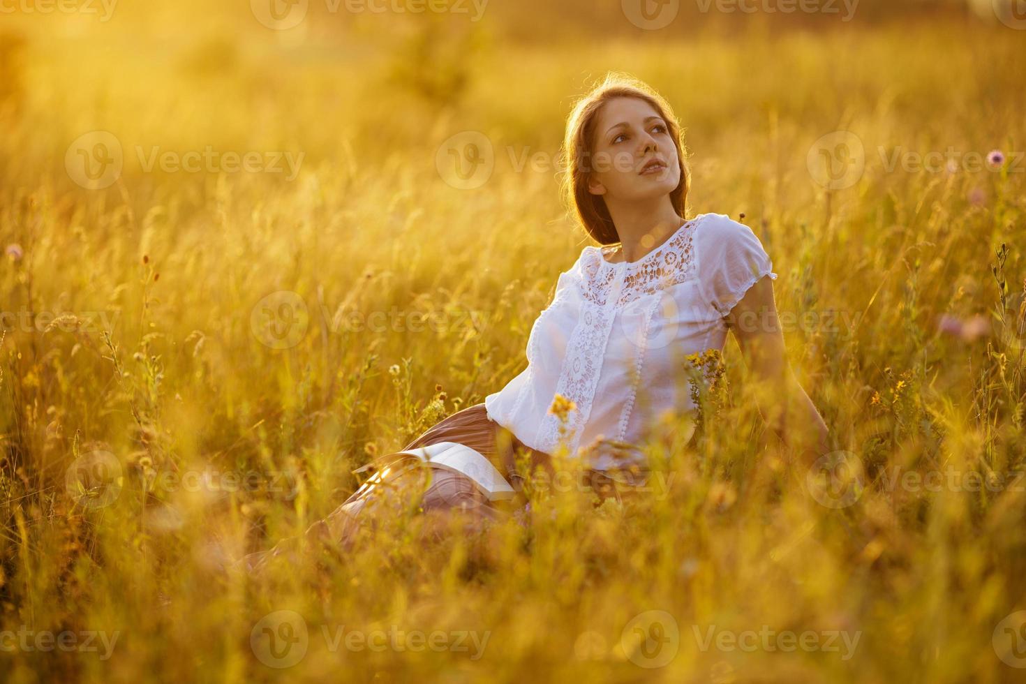 donna felice con un libro di fiori di campo foto