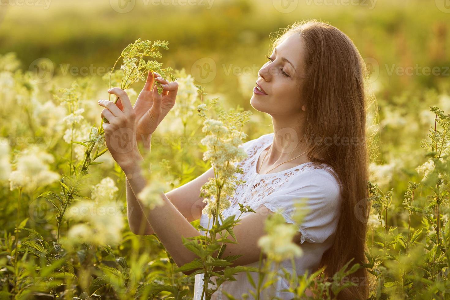 ragazza felice tra gli alti fiori di campo foto