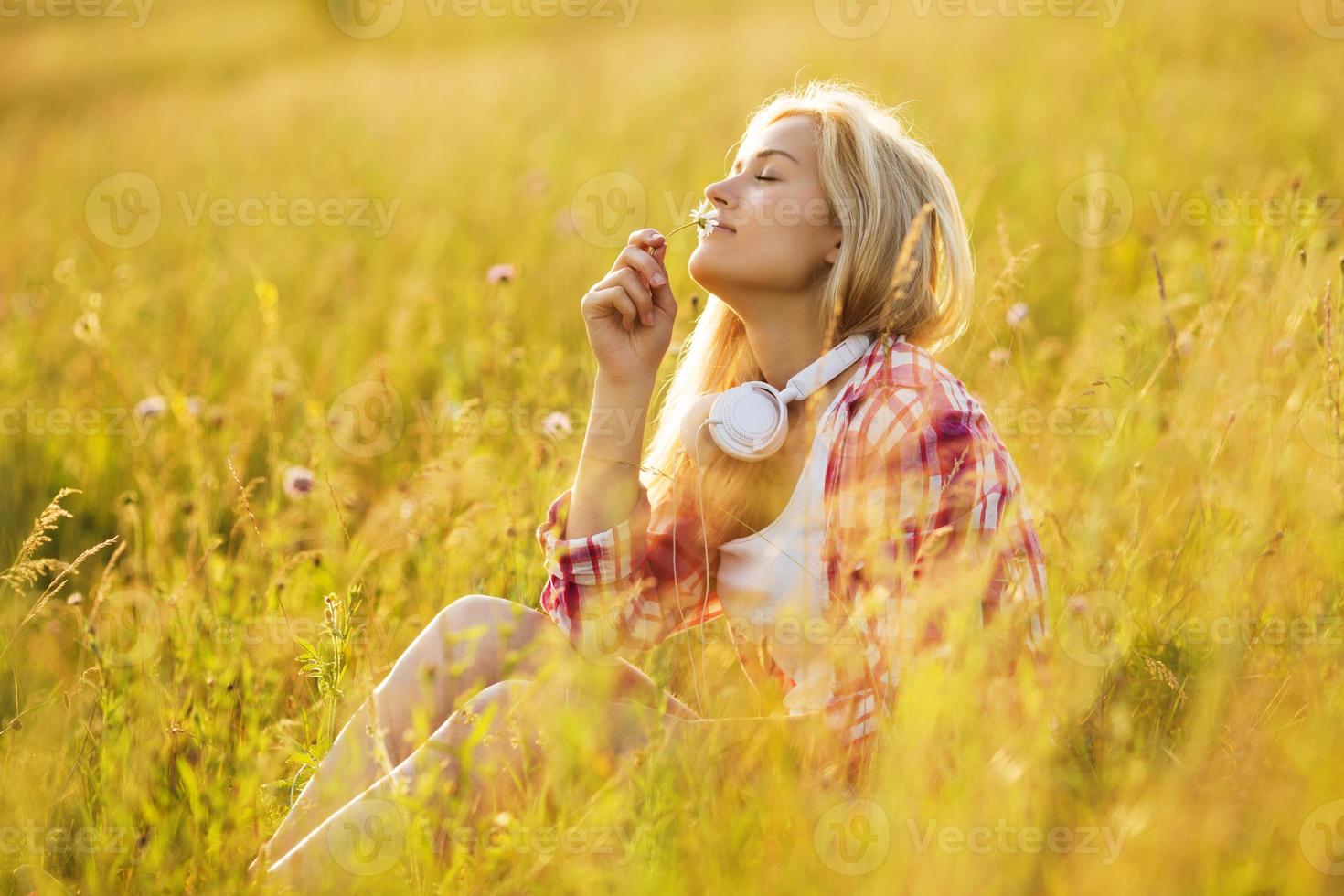 ragazza felice che odora un fiore foto