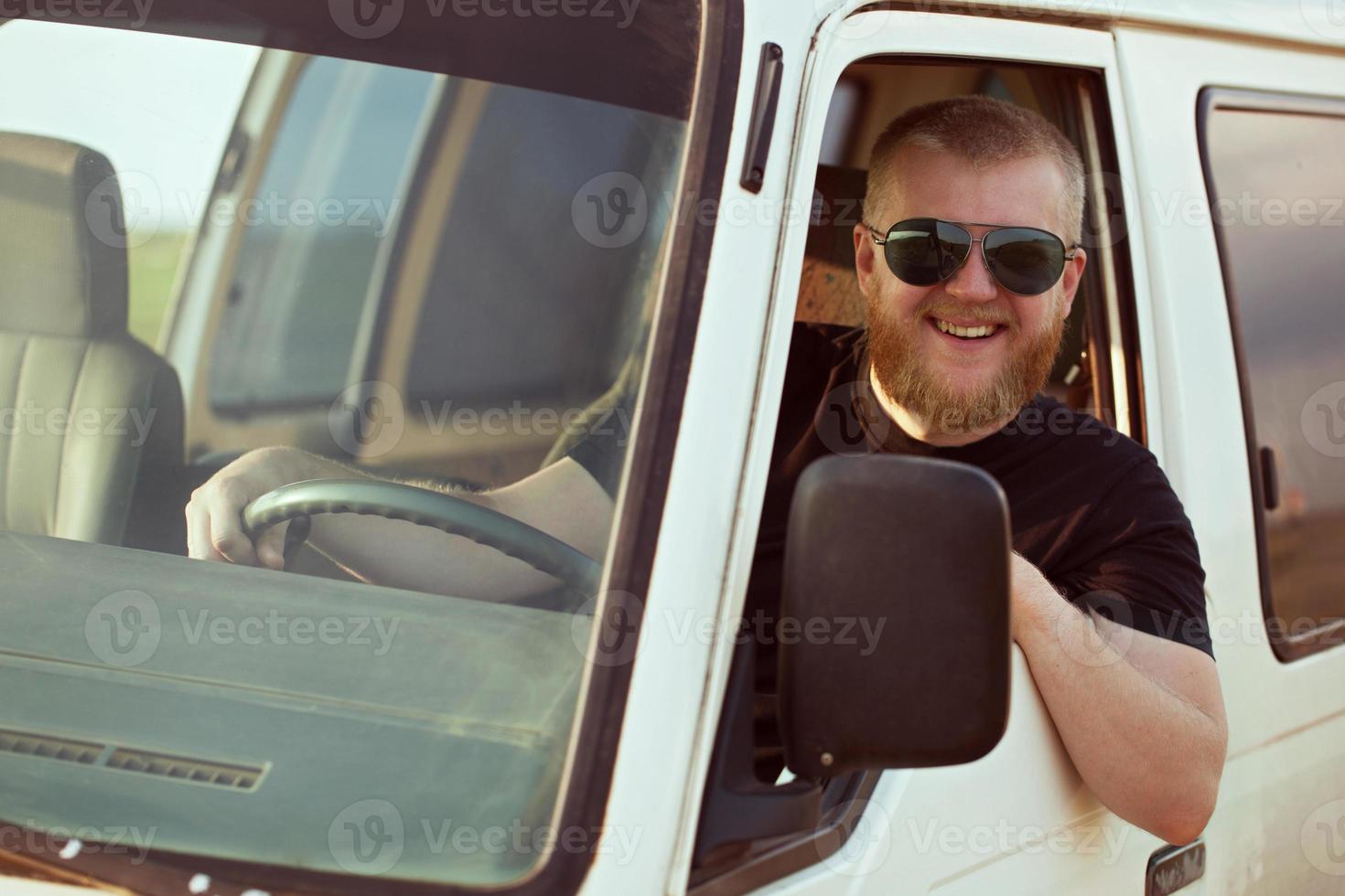 autista sorridente alla guida di un'auto foto