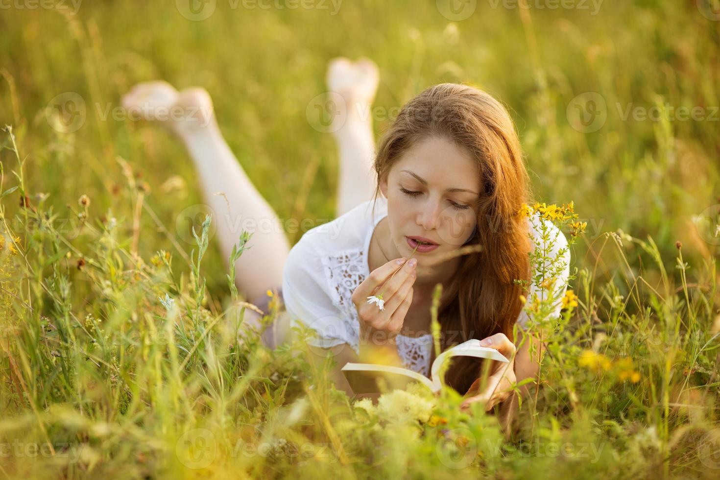 ragazza con un libro di fiori di campo foto