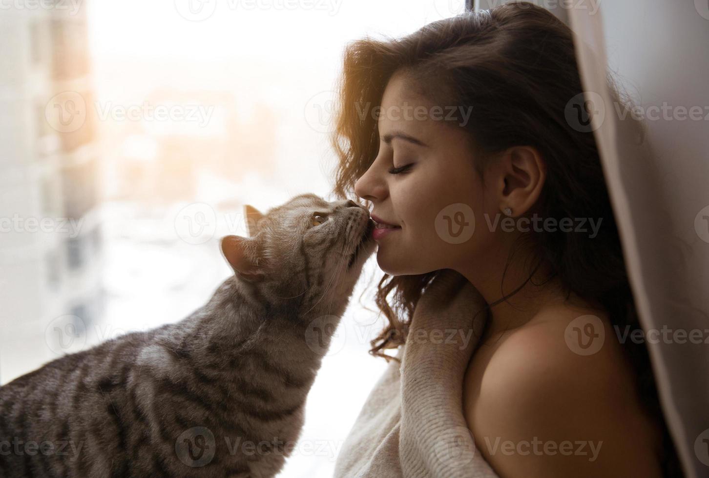 un grande gatto bacia una bella ragazza foto