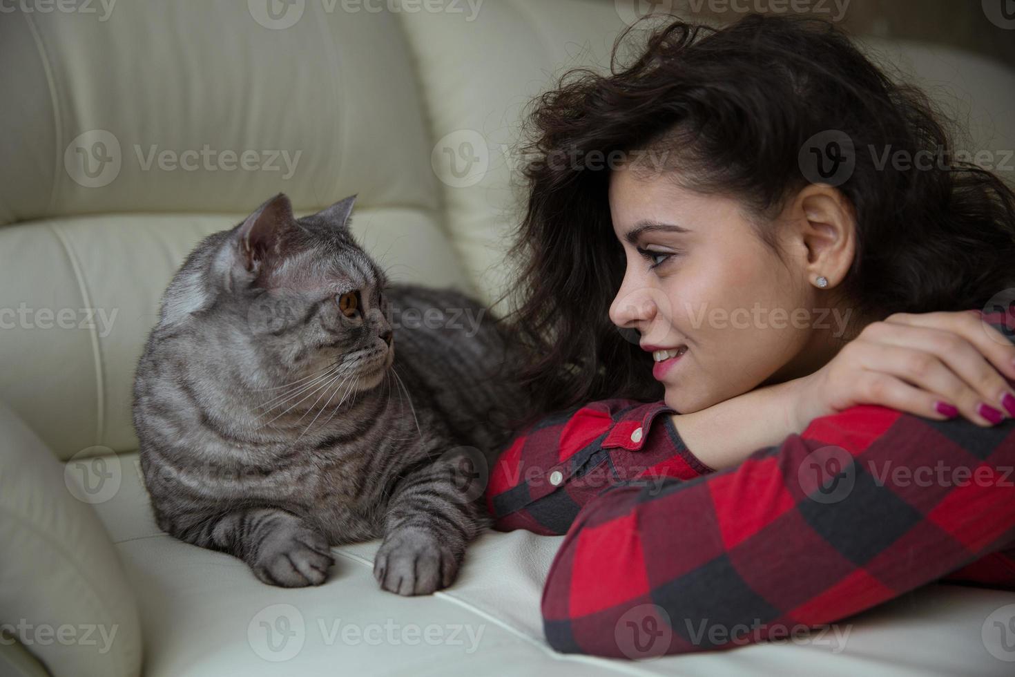 la giovane donna guarda un grosso gatto foto