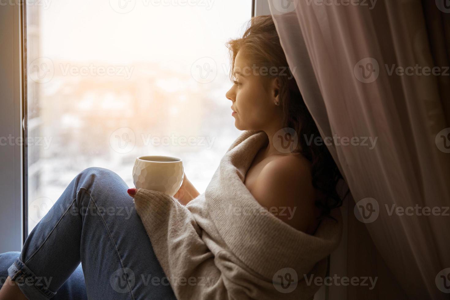 ragazza alla finestra con una tazza di caffè foto