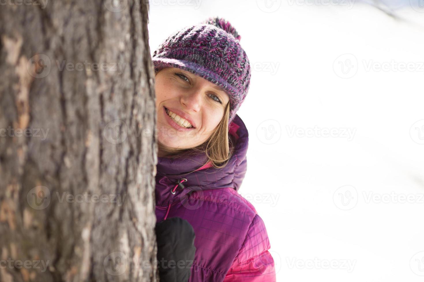 ragazza con un cappello costa vicino all'albero foto