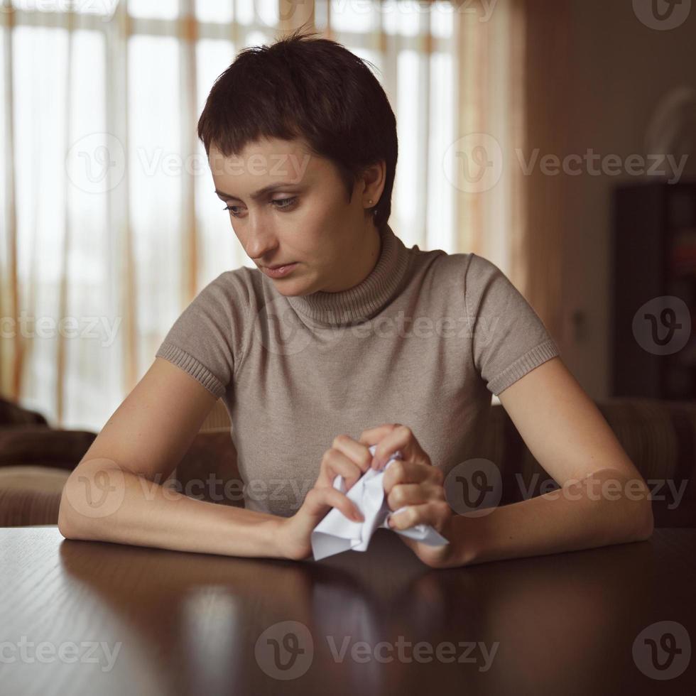 ragazza triste con in mano una lettera spiegazzata foto