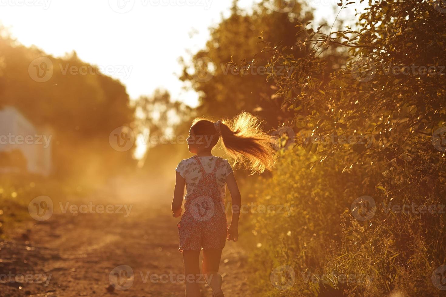 ragazza felice che corre lungo una strada di campagna foto