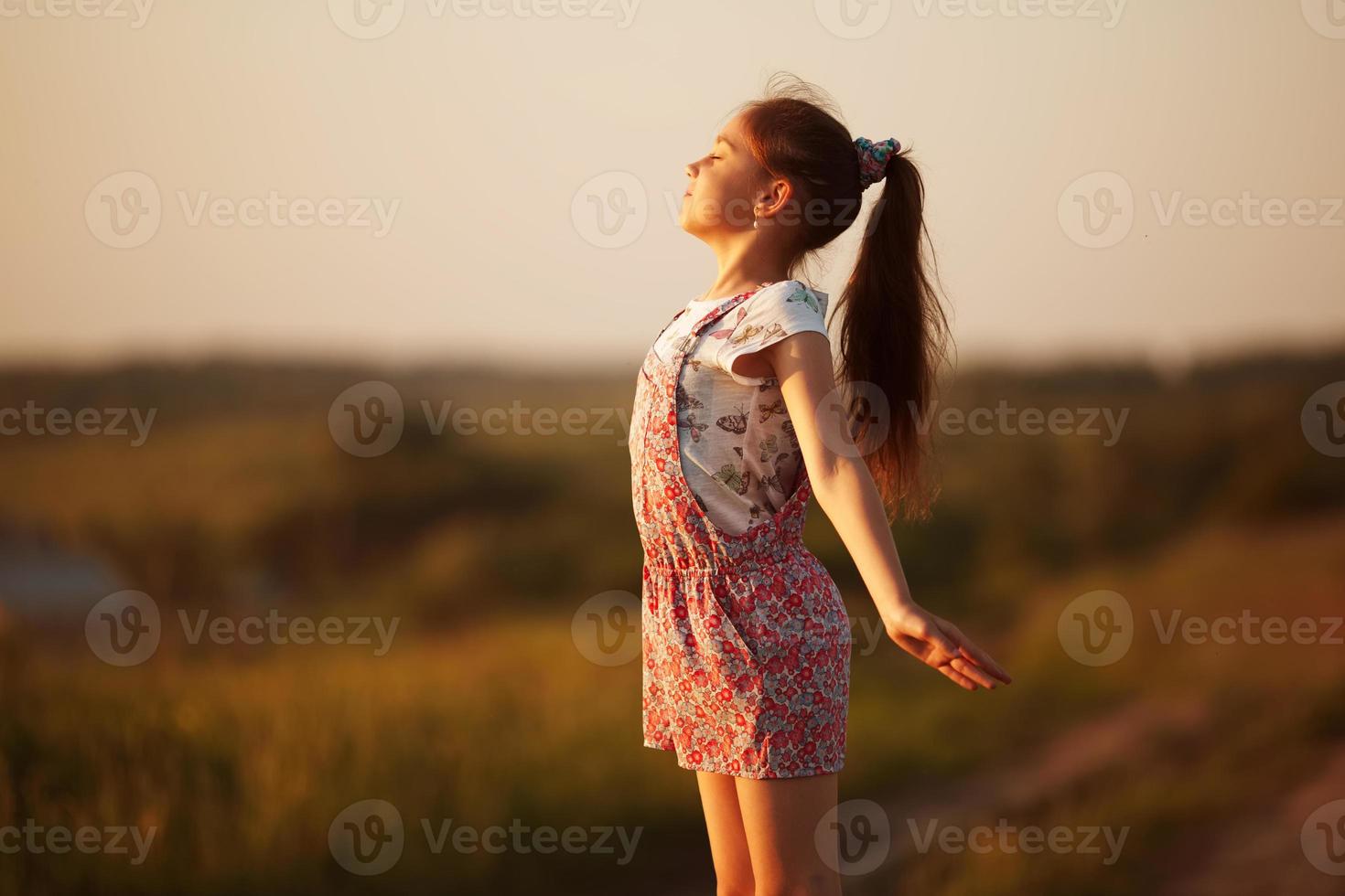 bambina felice si affaccia al sole foto