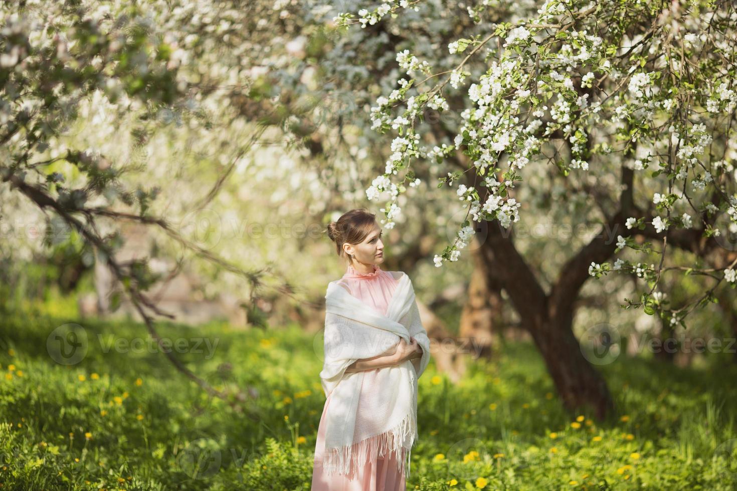 giovane donna felice tra i fiori di melo foto