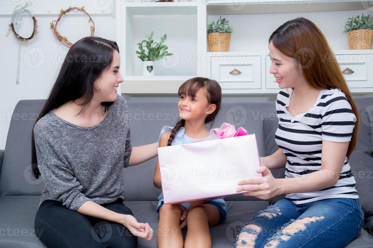 famiglia felice, madre e figlia che danno scatola regalo con la figlia. foto