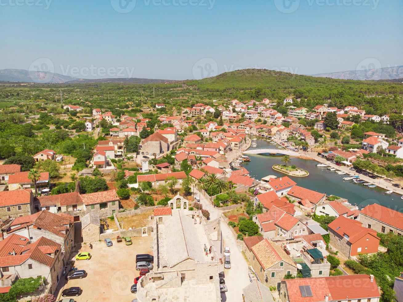 baia e città vecchia con chiesa a vrboska sull'isola di hvar croazia foto