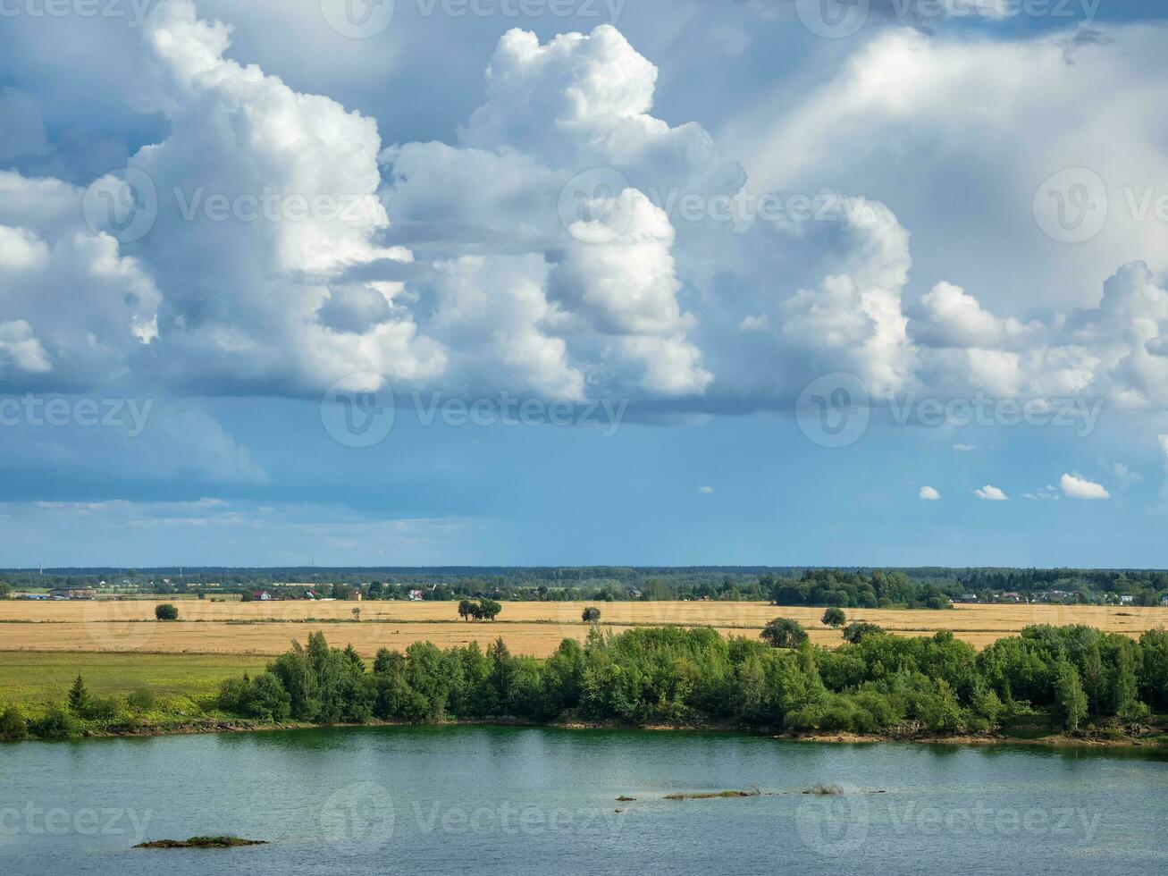 sorprendente paesaggio con grande bianca cumulo nuvole al di sopra di il lago e pianura. estate paesaggio su il banche di il verde fiume a tramonto. foto