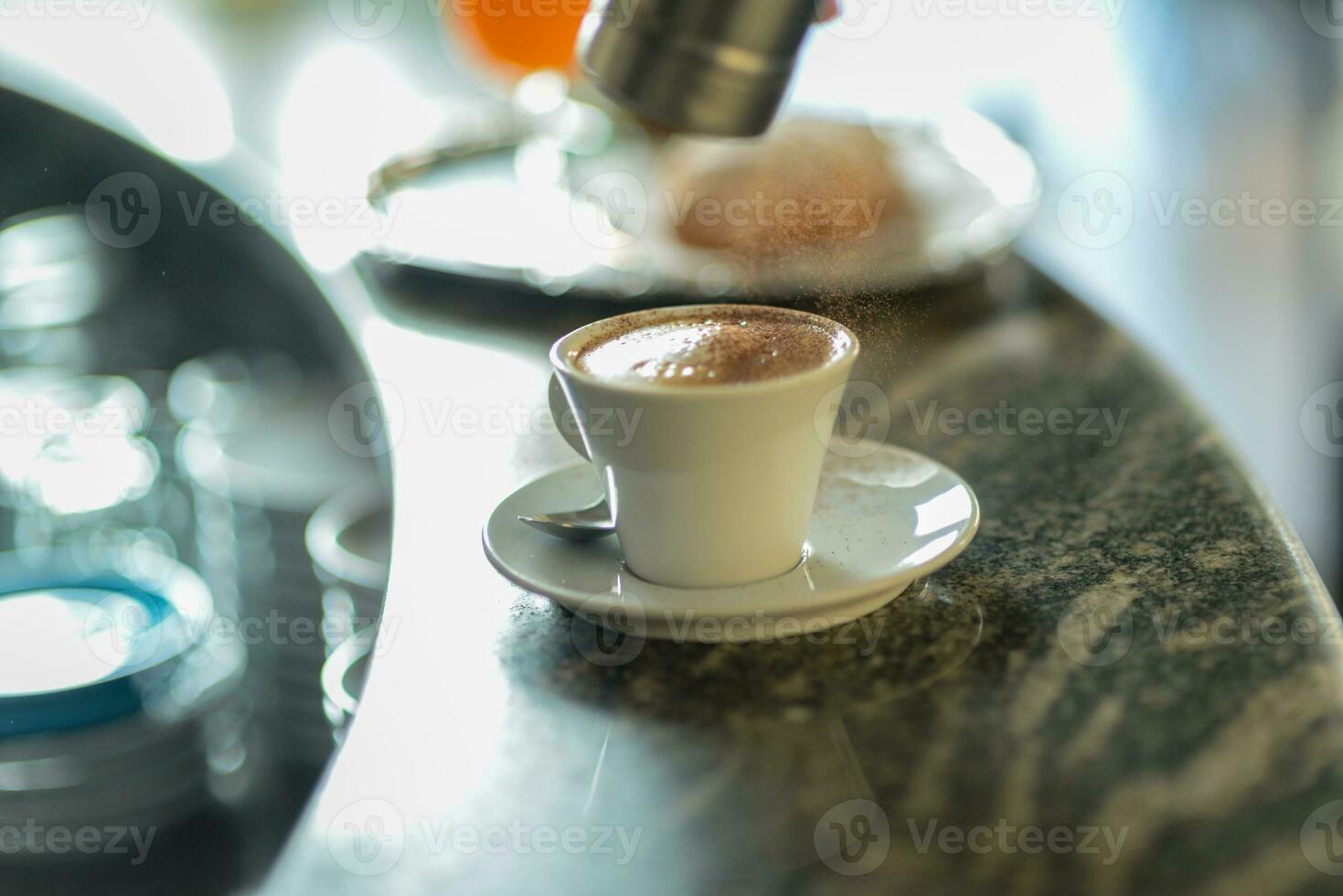 mani di giovane donna barista scrosciante al vapore cremoso latte su cappuccino tazza a il bar contatore. foto