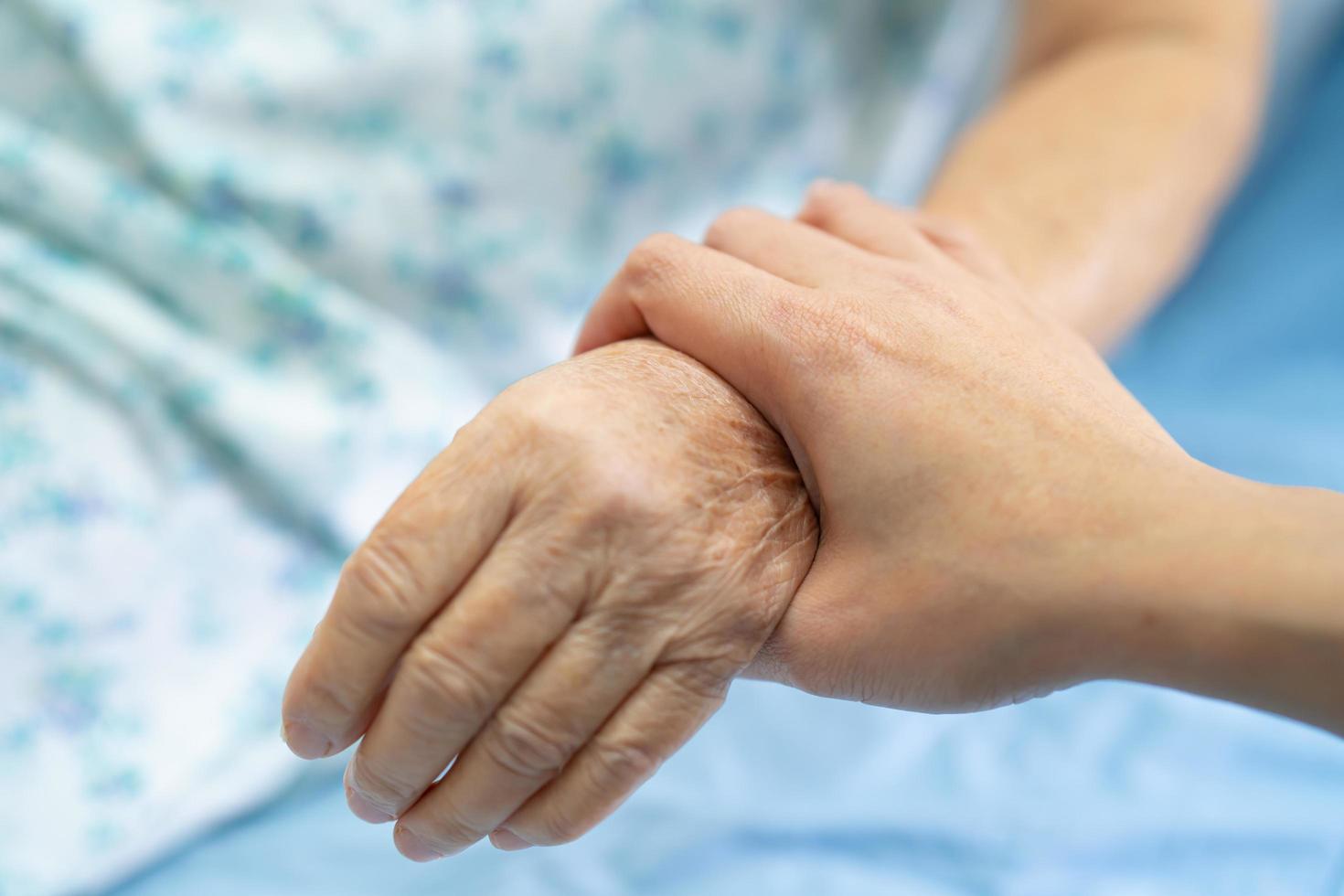 tenendo le mani toccanti donna anziana asiatica paziente con amore, foto