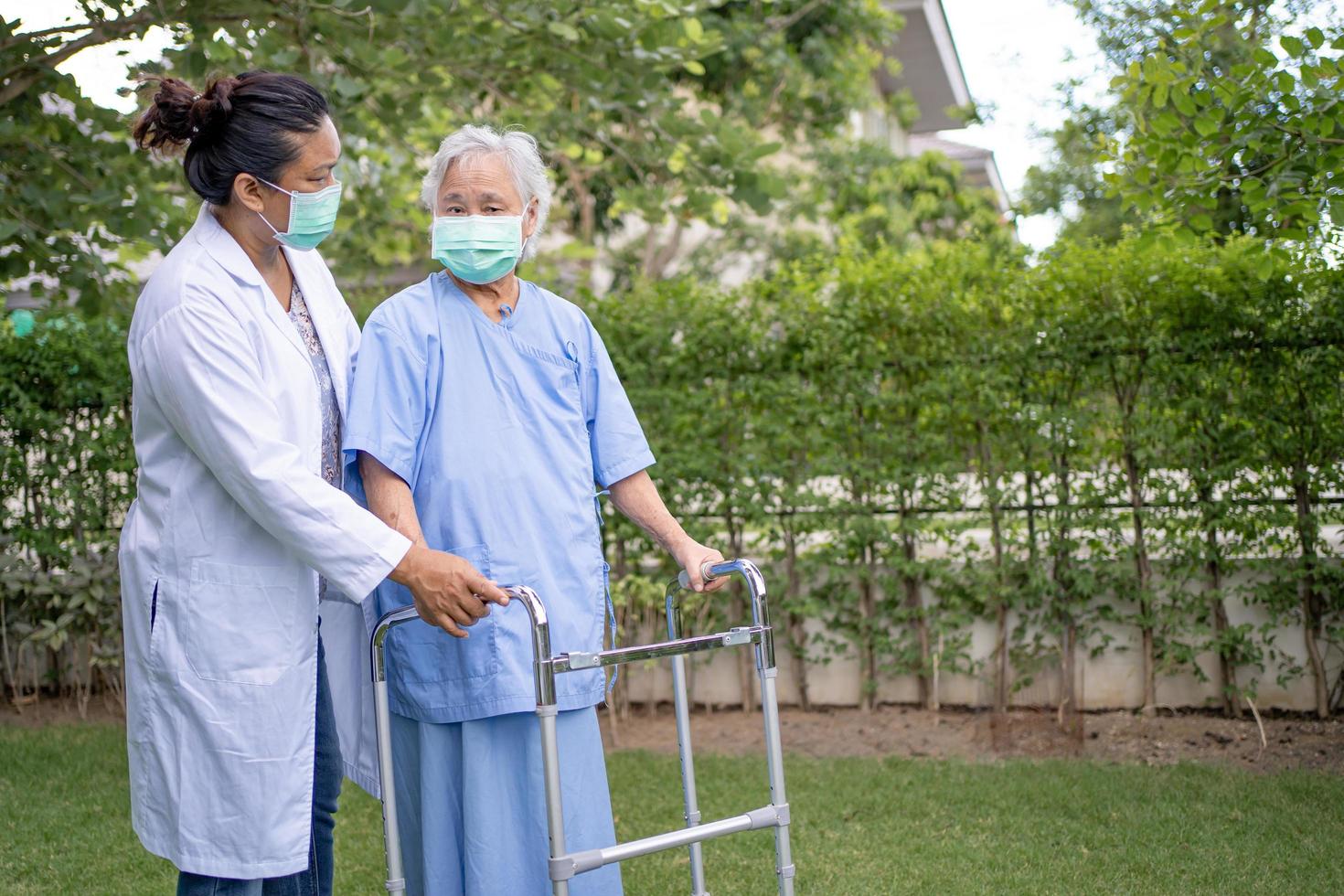 aiutare e curare la donna anziana asiatica usa il camminatore con una buona salute foto