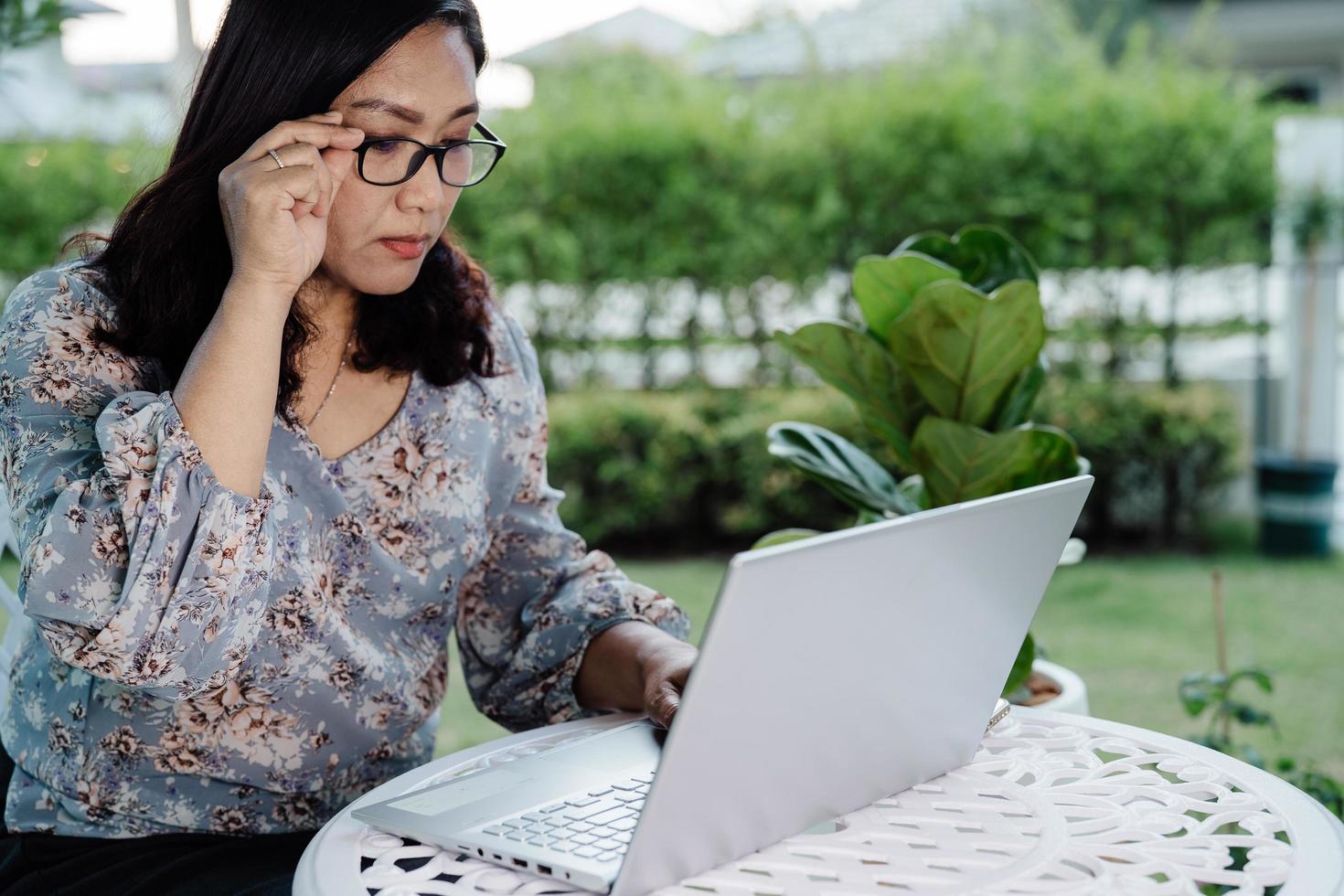 donna d'affari asiatica lavora da casa sul laptop, resta a casa. foto