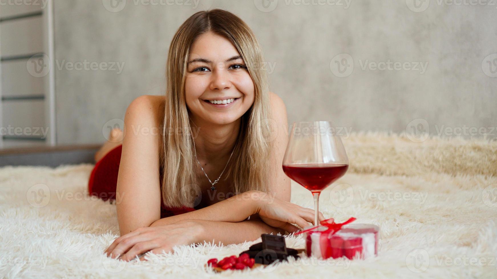 una bella bionda sorridente si trova a letto. San Valentino mattina foto