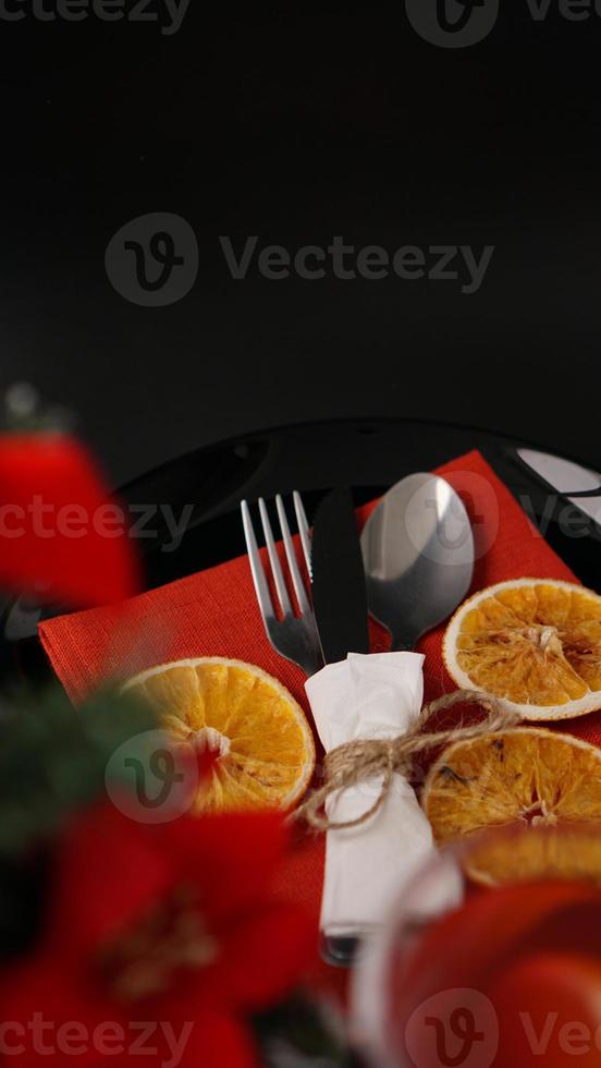 impostazione per la cena di Natale festiva sulla tavola nera con decorazioni foto