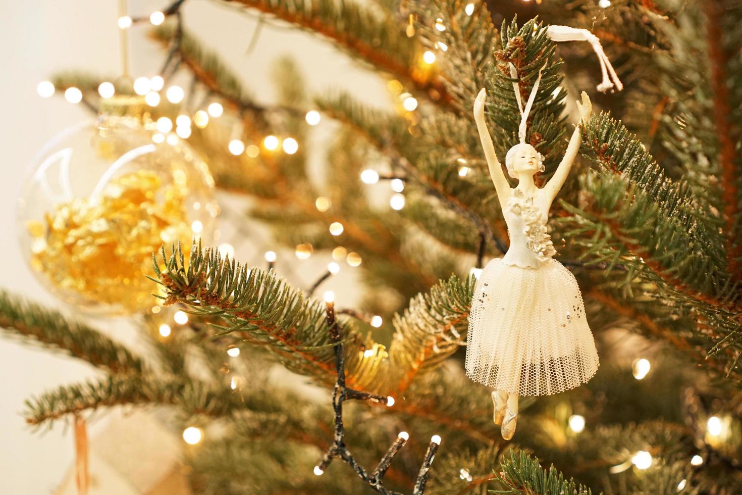 bella ballerina decora un ramo di un albero di natale foto
