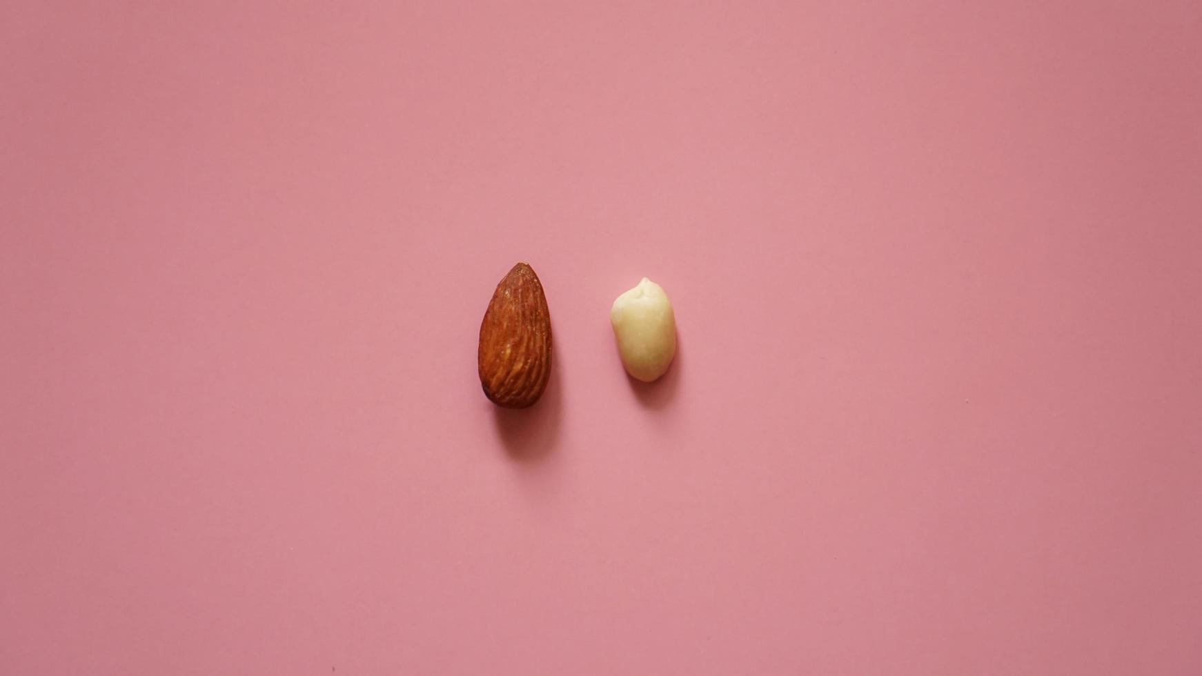 mandorle e arachidi su sfondo rosa foto