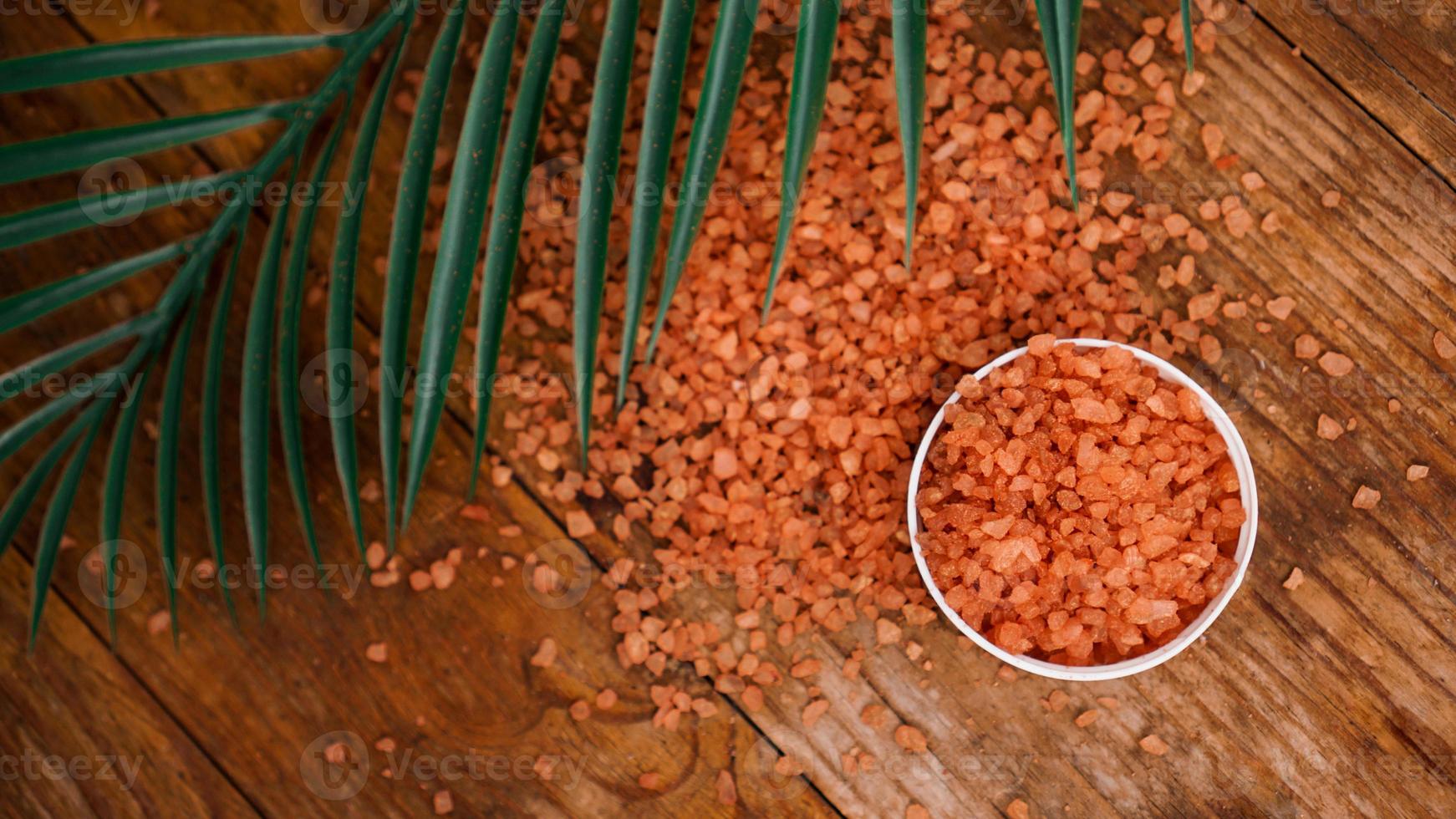 sale marino arancione su un fondo di legno. foglie di palma tropicale foto