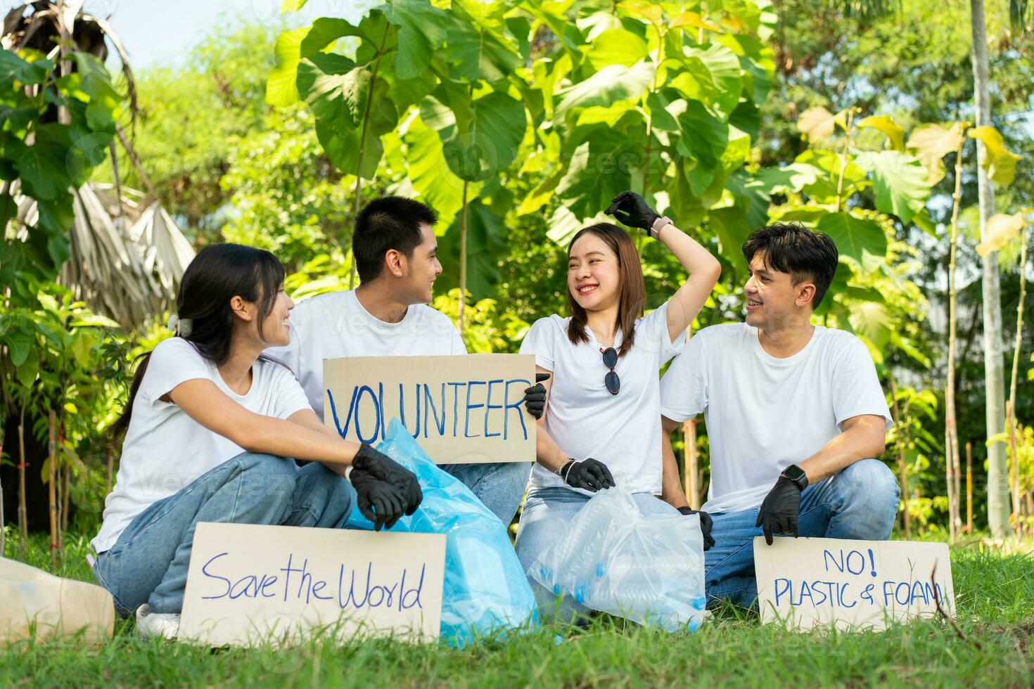 contento giovane asiatico studenti diverso volontari hold un' campagna cartello per pulizia nel il parco, il concetto di ambientale conservazione su mondo ambiente giorno, raccolta differenziata, beneficenza per sostenibilità. foto