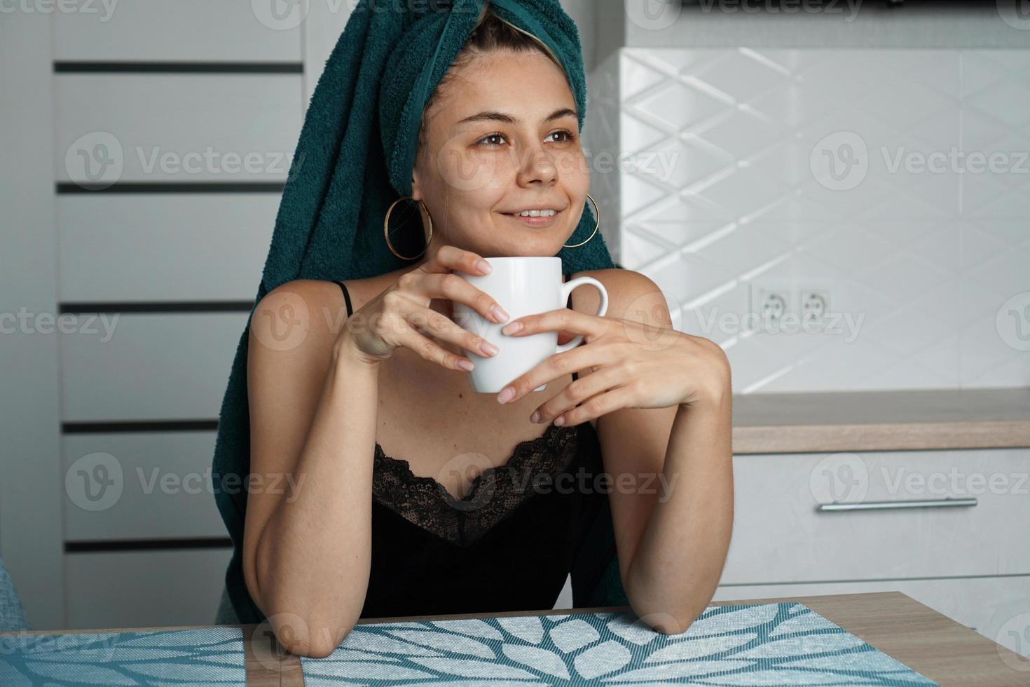 bella donna si siede in cucina con una tazza di caffè foto