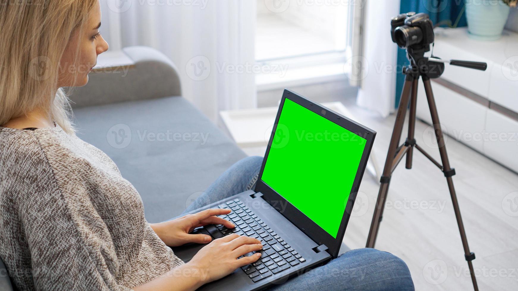 vista della fotocamera su treppiede e laptop con chromakey schermo verde foto