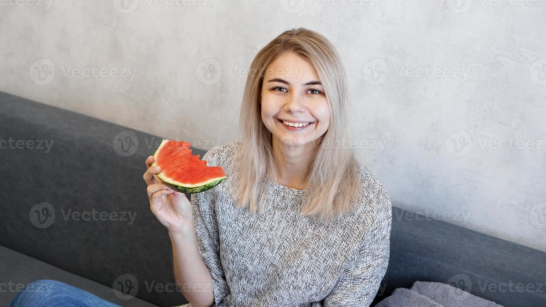 giovane donna attraente che mangia anguria foto