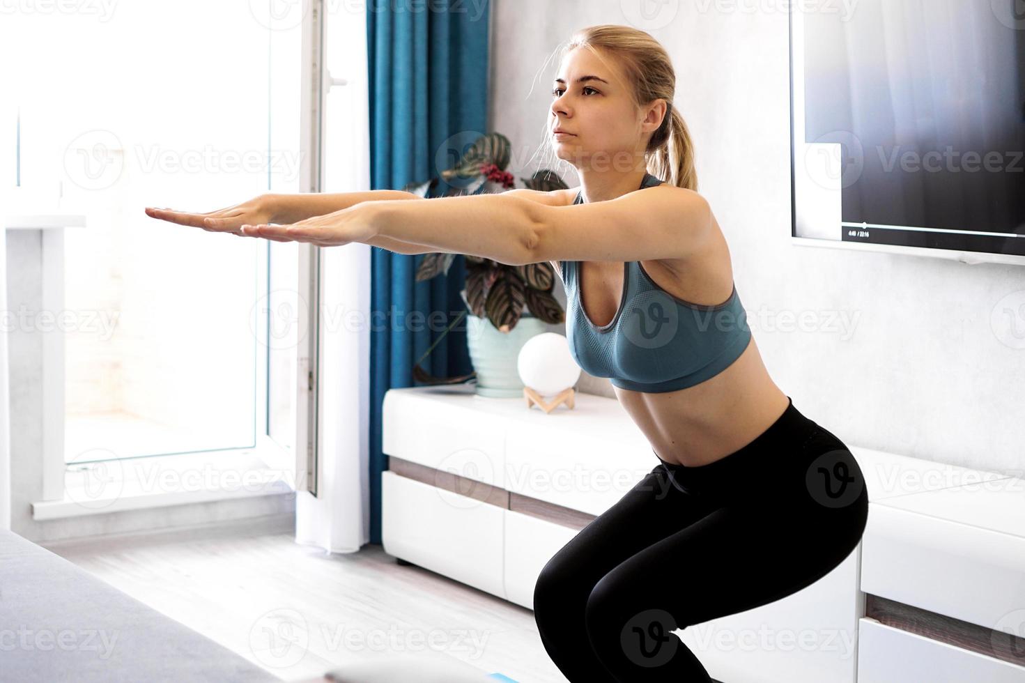 concetto di allenamento e stile di vita - donna che si esercita e fa squat foto