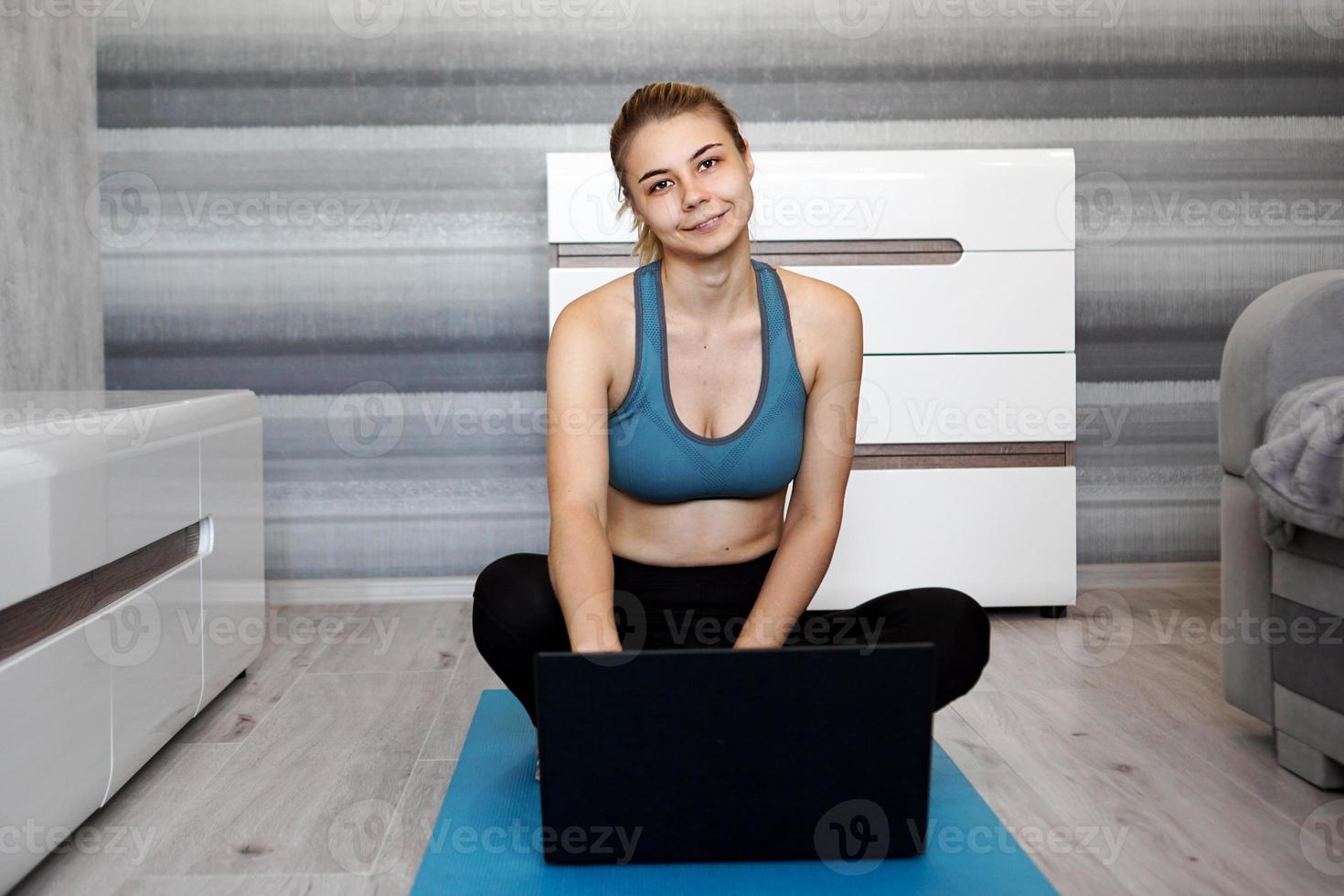 ragazza che si allena a casa e guarda video sul laptop, si allena foto