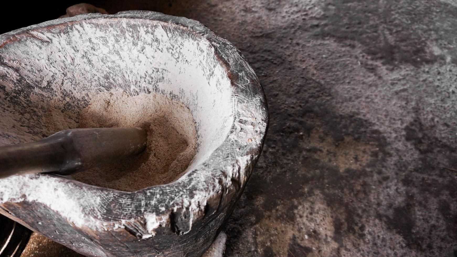 antico mortaio di farina. recipiente di legno per la molatura manuale a mano foto