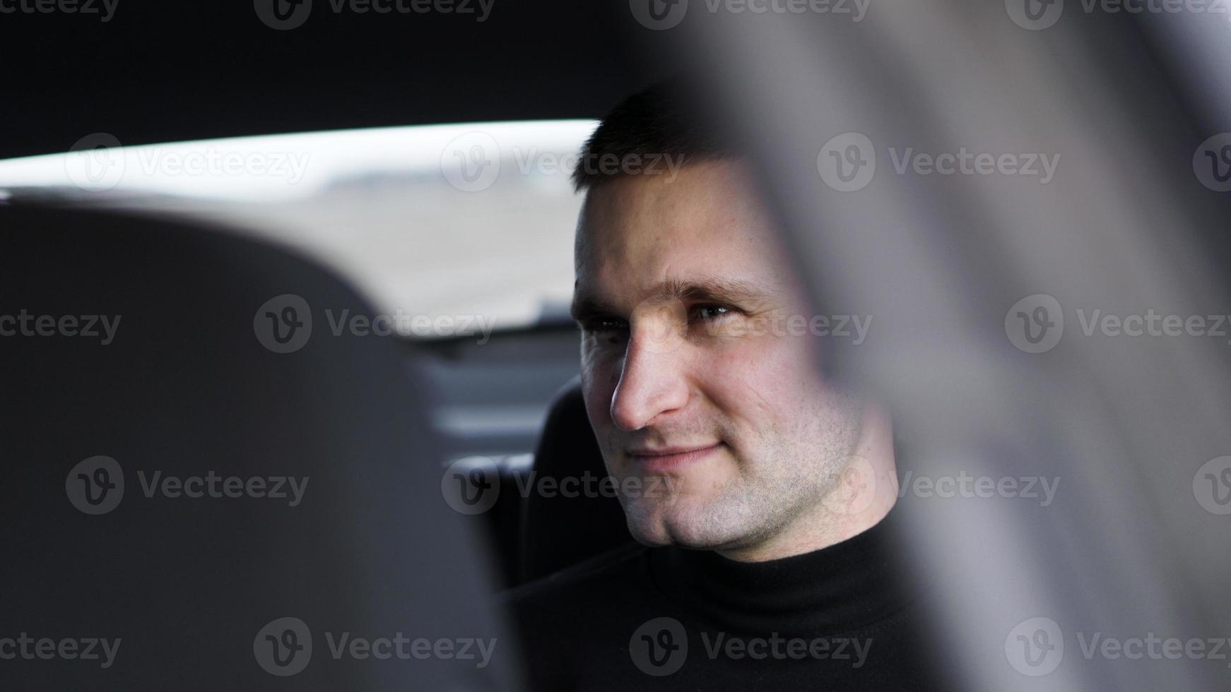 uomo d'affari sorridente seduto sul sedile posteriore di un'auto foto