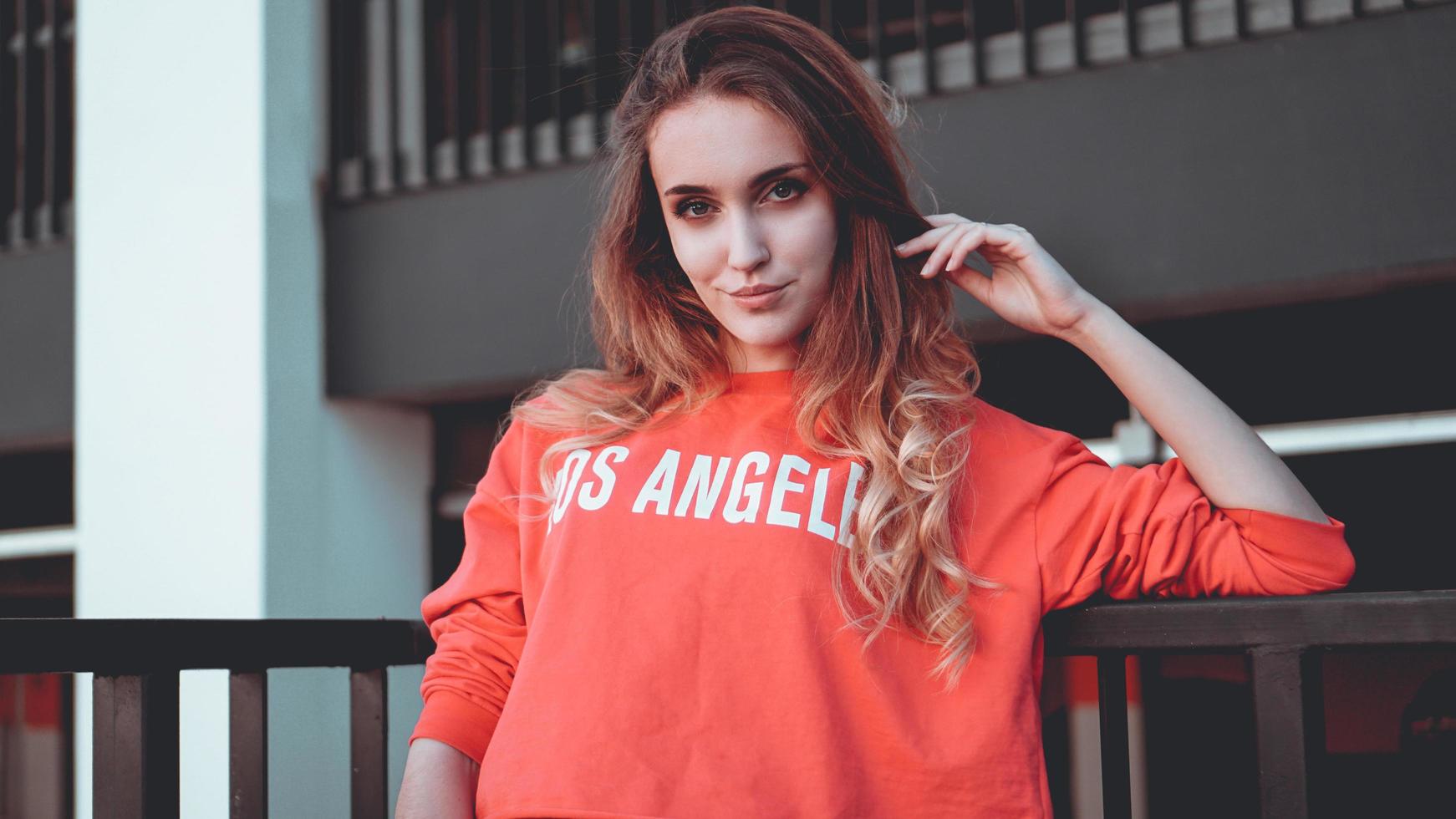 modella che indossa una felpa con cappuccio rossa con scritta los angeles foto