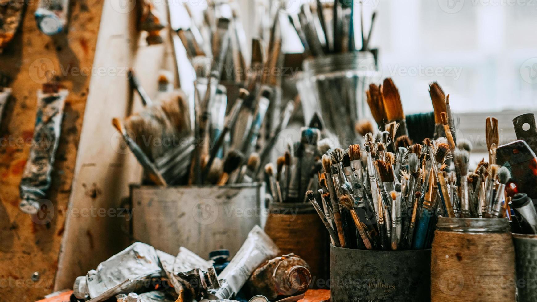 tavolo con pennelli e strumenti in laboratorio d'arte. sfondo. foto