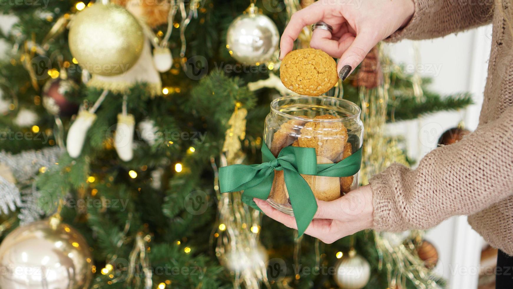 biscotti di avena in un barattolo di vetro. sullo sfondo delle decorazioni natalizie foto