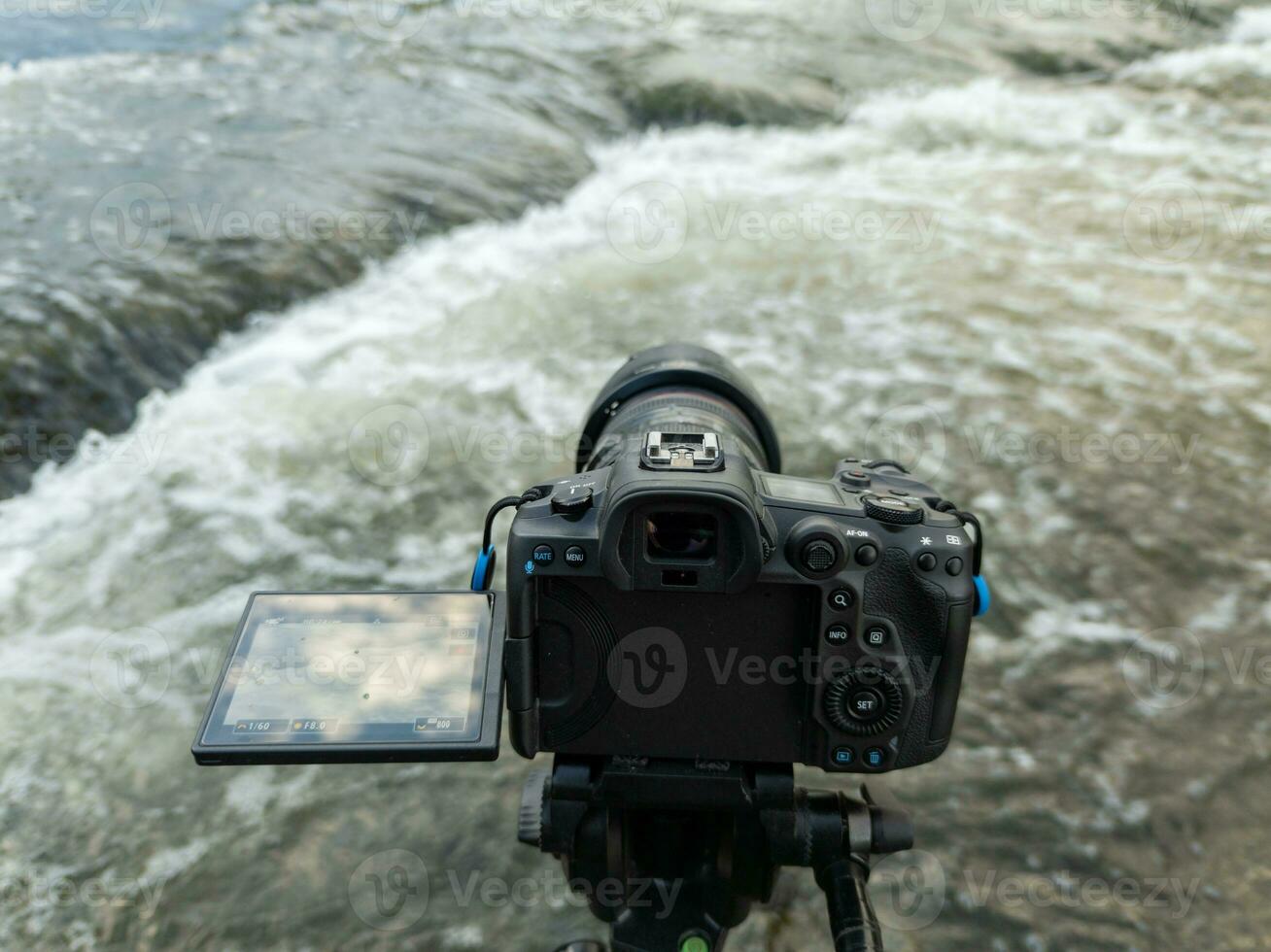 moderno nero digitale mirrorless telecamera con schermo a fogli mobili su tripode cattura streaming acqua, avvicinamento foto