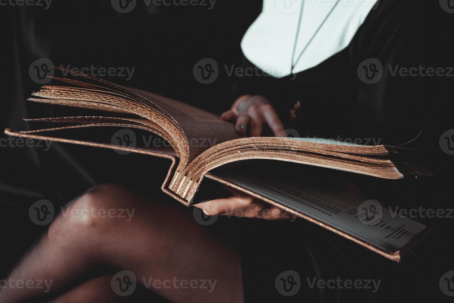suora in abito religioso nero tiene la Bibbia. concetto di religione foto
