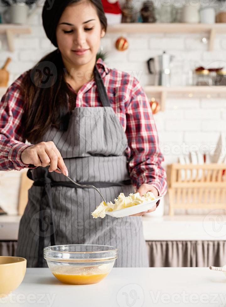giovane donna latina che cucina in cucina foto