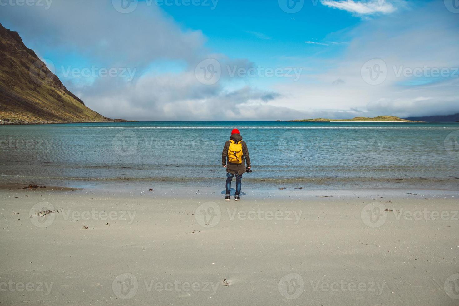 uomo con uno zaino su una spiaggia foto