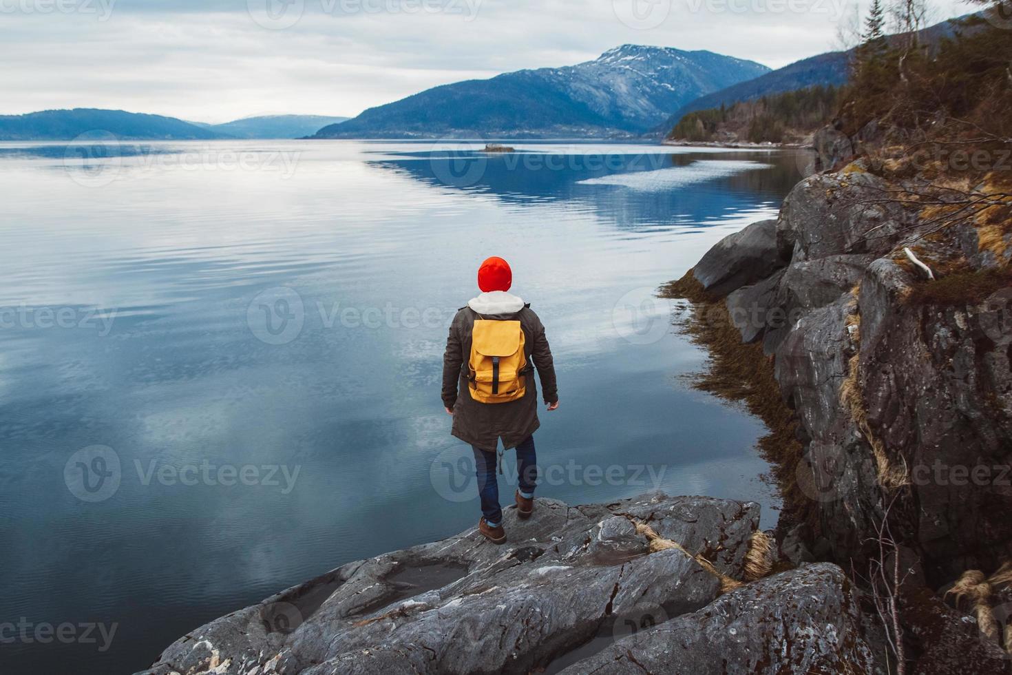 uomo in piedi in riva al lago foto