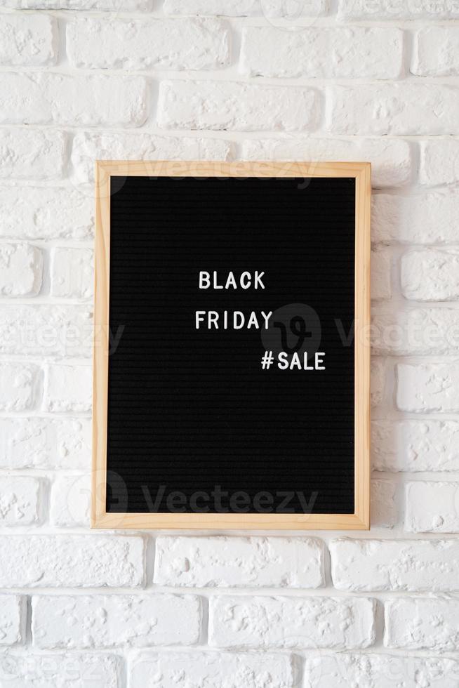 testo vendita venerdì nero su cartoncino nero su muro di mattoni bianchi foto