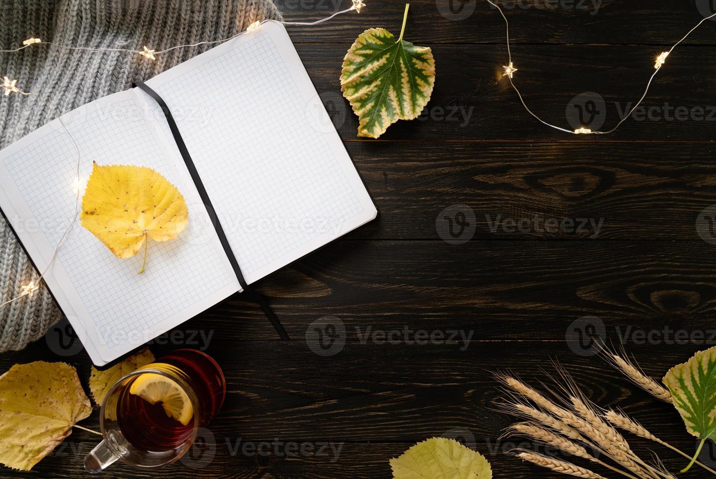 spazio di lavoro con taccuino, tazza di tè al limone foto