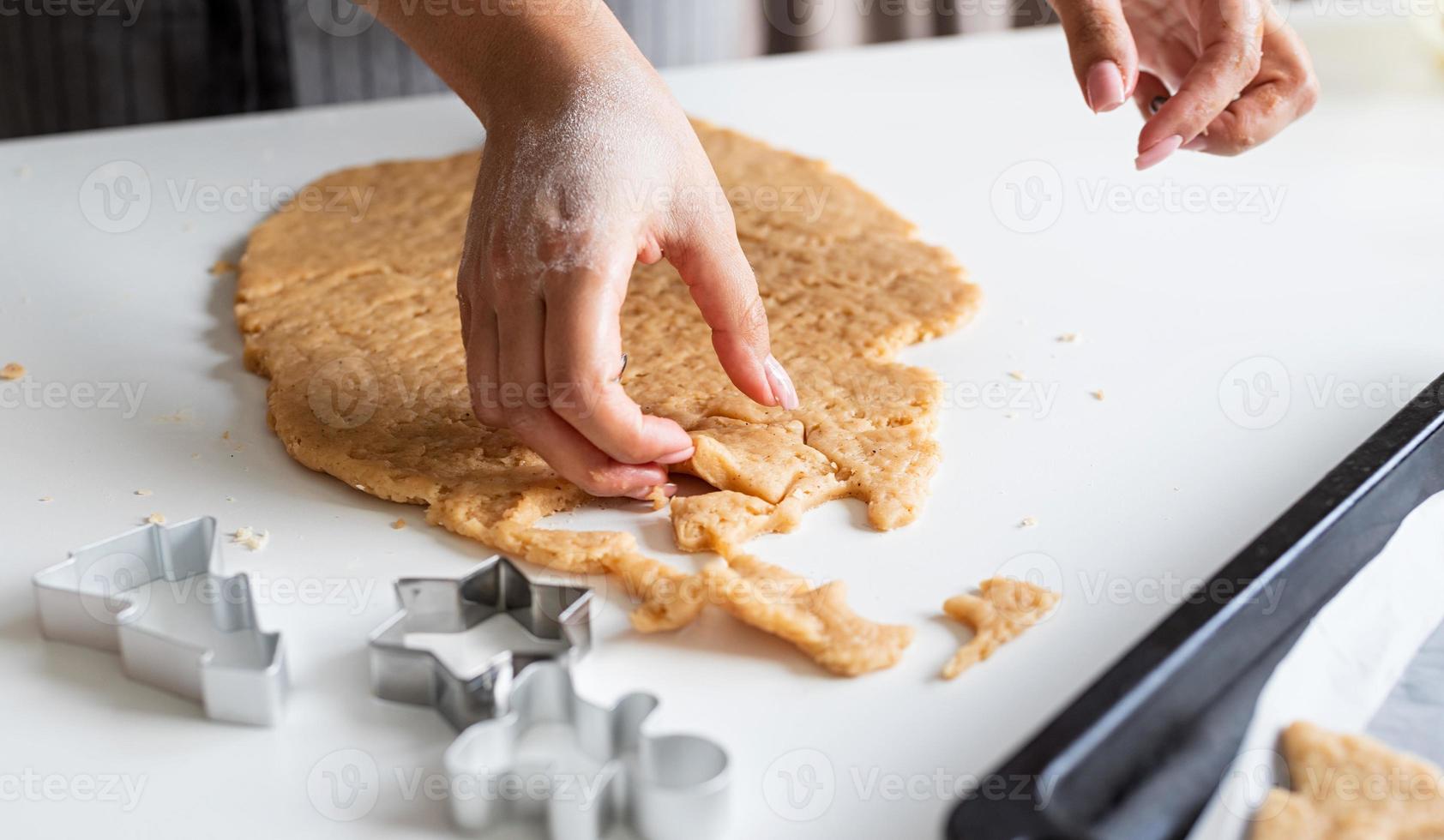 mani di donna che cuociono i biscotti in cucina foto