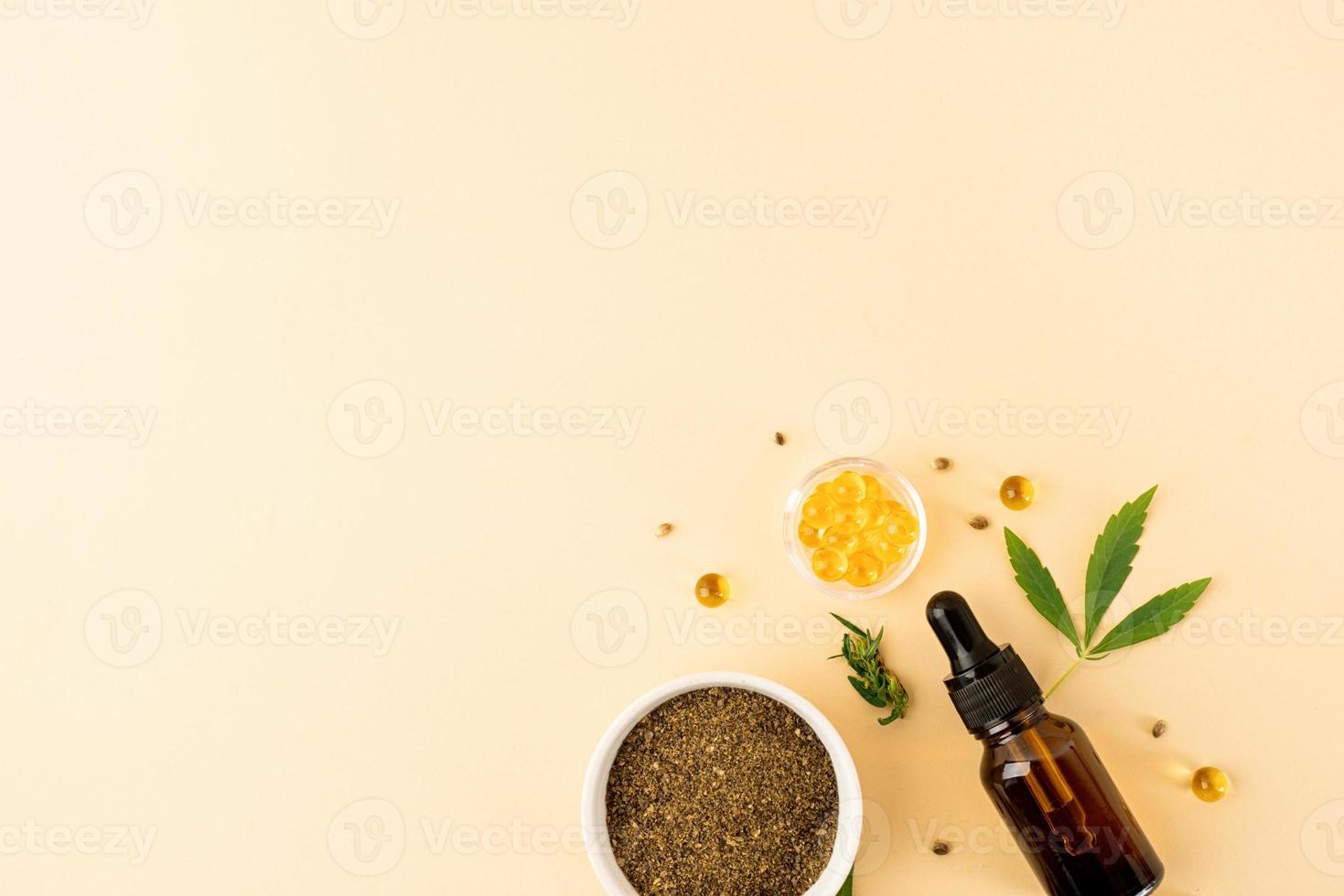 olio di CBD e foglie di cannabis cosmetici vista dall'alto su sfondo arancione foto