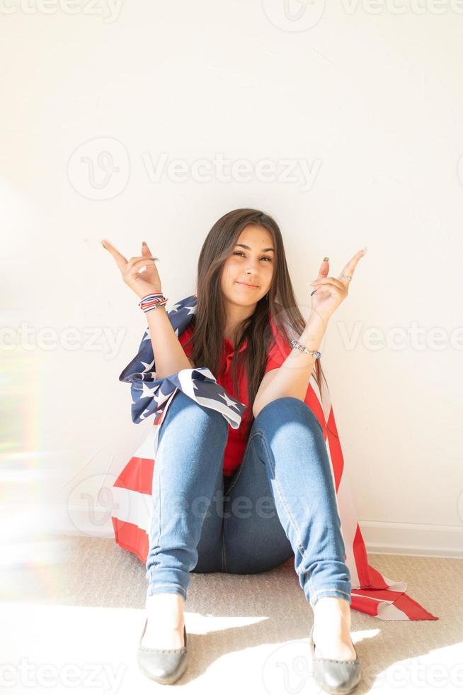 bella giovane donna con bandiera americana su sfondo bianco foto