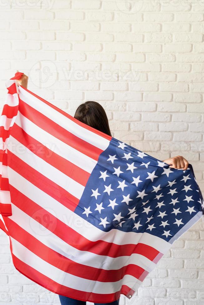 bella giovane donna con bandiera americana, vista da dietro foto