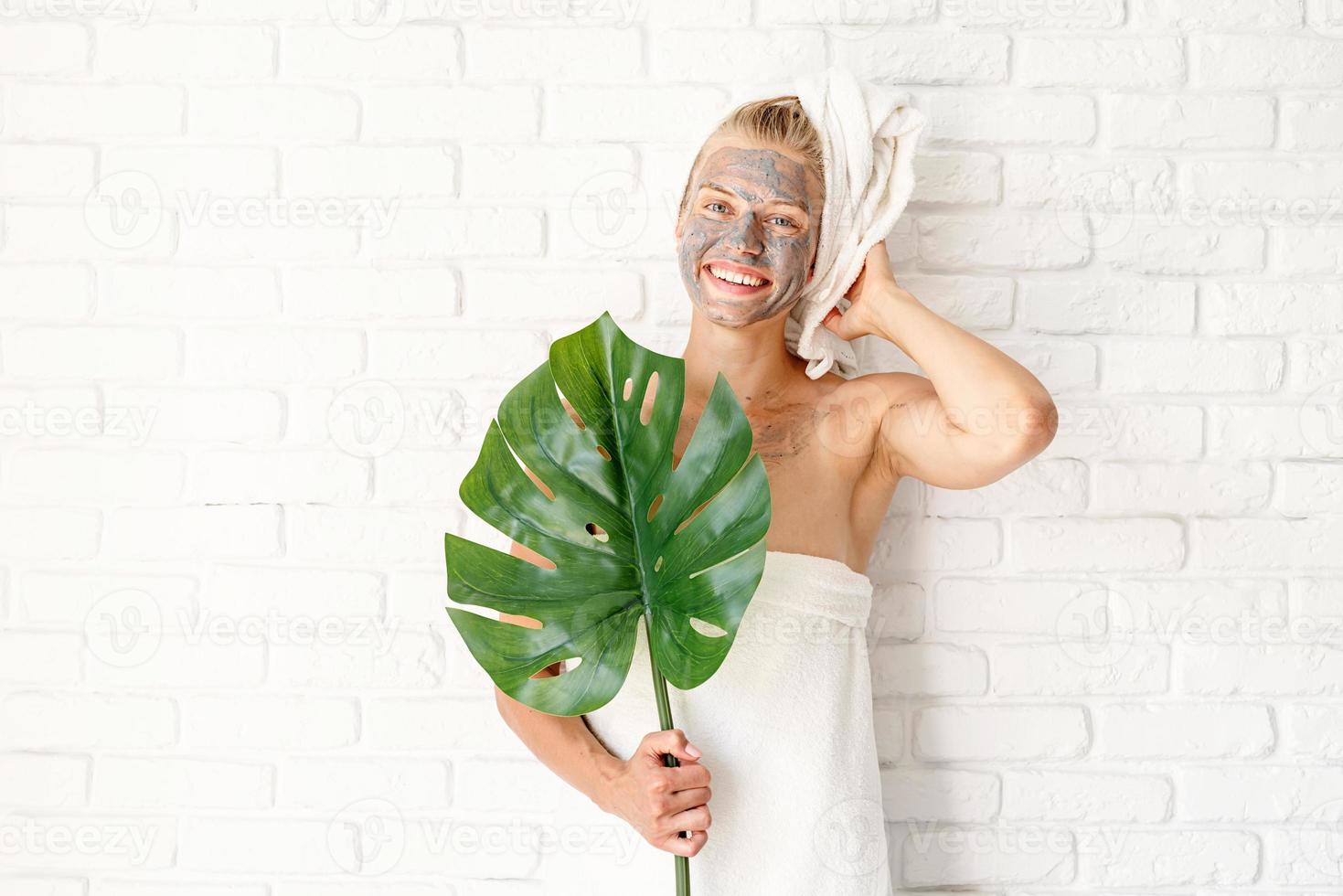 donna che tiene una foglia verde di monstera foto