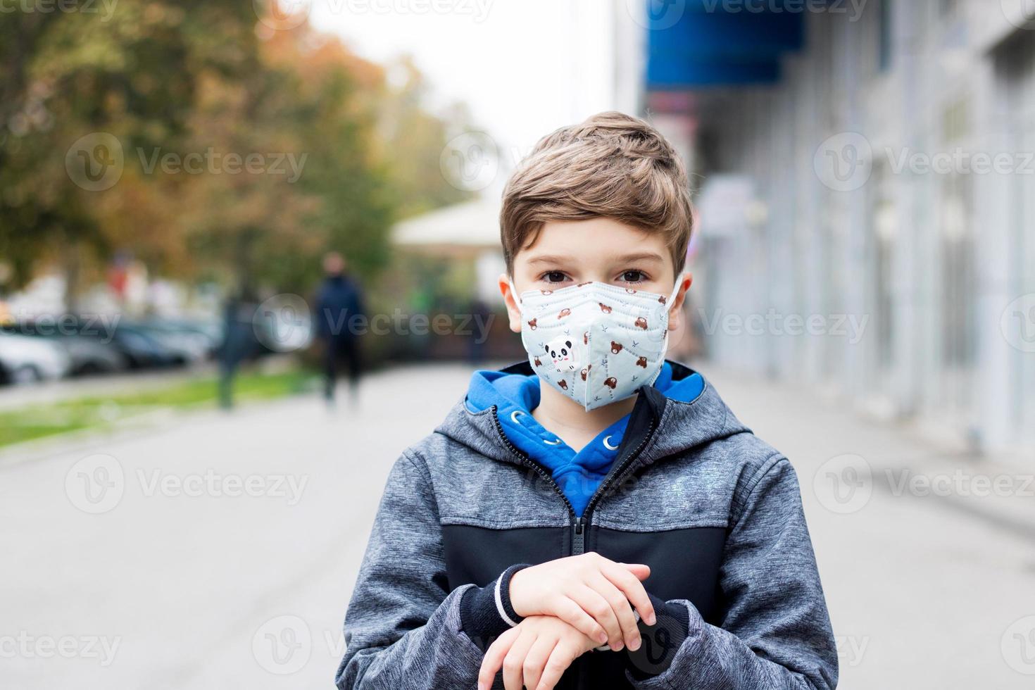 il bambino indossa la maschera facciale in città durante la pandemia di coronavirus. foto